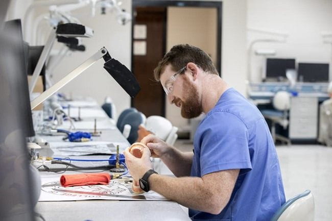 A dental student working on a dental mold.